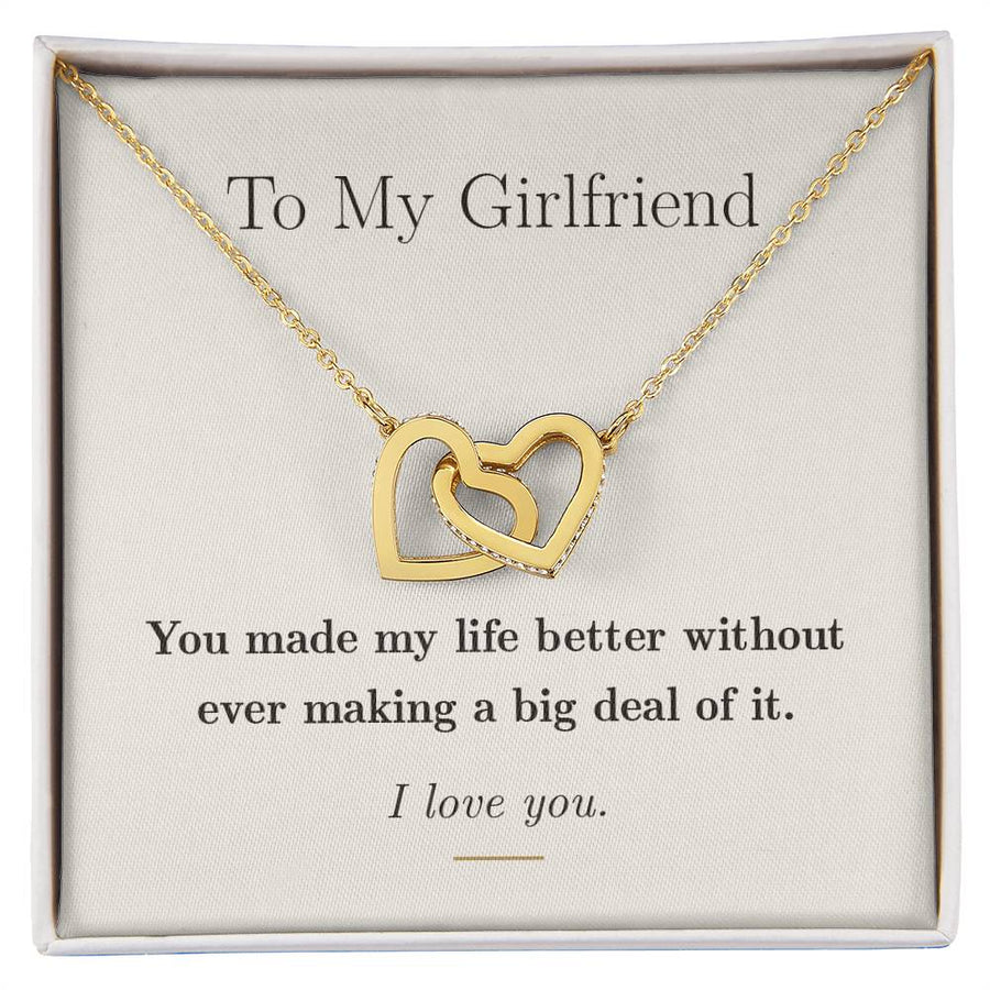 The message card with the interlocking hearts necklace resting on it